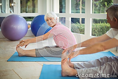 Senior couple performing stretching exercise on exercise mat Stock Photo