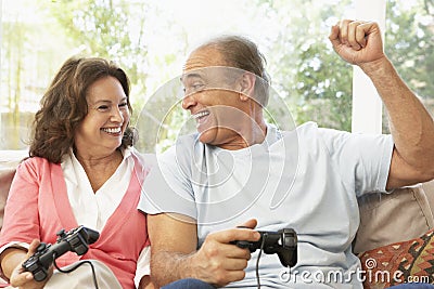 Senior Couple Playing Computer Game At Home Stock Photo