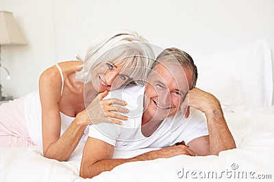 Senior Couple Relaxing On Bed Stock Photo