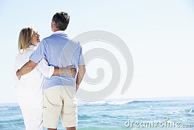 Senior Couple Relaxing By Ocean Stock Photo