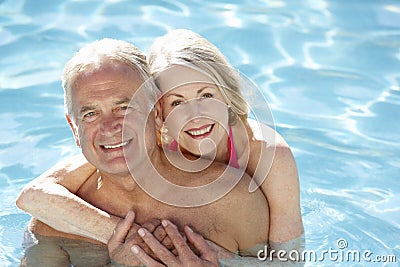 Senior Couple Relaxing In Swimming Pool Together Stock Photo