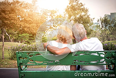 Senior couple siting on a bench and having romantic and relaxing time in a park Stock Photo