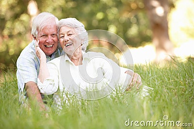 Senior Couple Sitting In Park Stock Photo