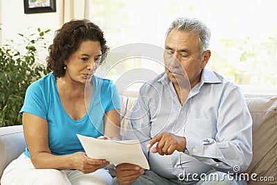 Senior Couple Studying Financial Document At Home Stock Photo