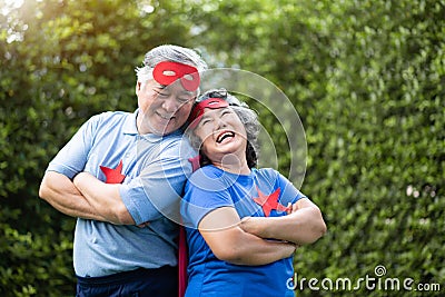 Senior couple in Superhero costume lauging with arms crossed Stock Photo