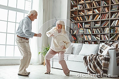 Senior couple together at home retirement concept dancing active dance playful Stock Photo