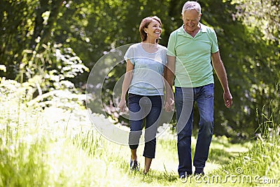 Senior Couple Walking In Summer Countryside Stock Photo