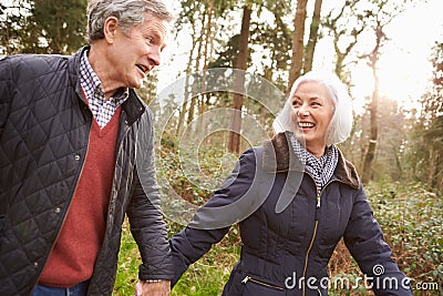 Senior Couple Walking Through Winter Countryside Stock Photo