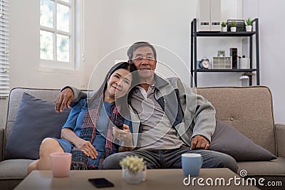 Senior couple watching tv and sofa in relax for movie or series in living room at home. Elderly man and woman with Stock Photo