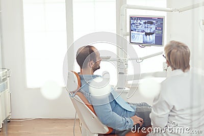 Senior dentist talking with sick man about mouth hygine showing x-ray Stock Photo