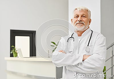 Senior doctor in coat with arms crossed. Stock Photo