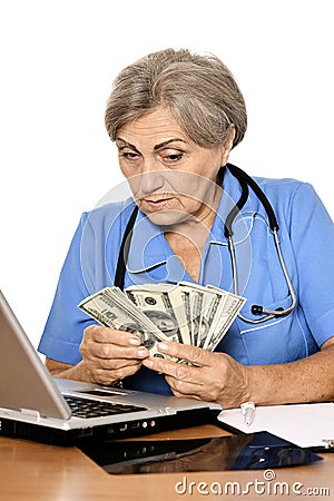 Senior doctor with laptop and dollars Stock Photo