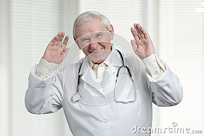 Senior doctor laughing hard with raised hands up. Stock Photo