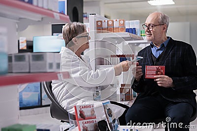 Senior drugstore client selecting heart health supplements in pharmacy Stock Photo