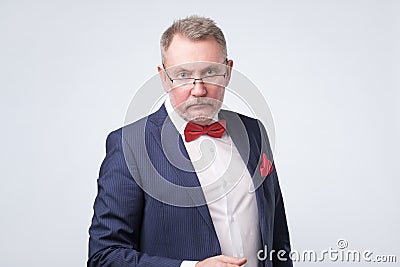 Senior european man in blue suit and glasses looking at camera Stock Photo