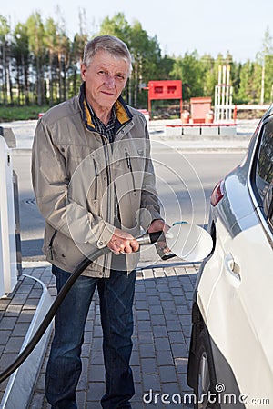 Senior European man filling own car with gasoline in gas stations Stock Photo