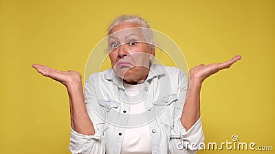 Senior European woman shrugs her shoulders in confusion Stock Photo