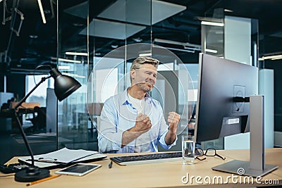 Senior experienced businessman, looks frustrated at the monitor, complains about poor performance, man at work Stock Photo