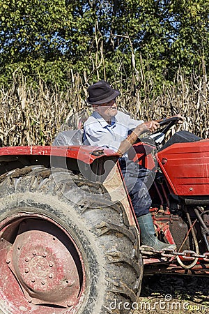 Senior farmer using an old tractor to plow his land Stock Photo