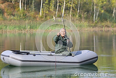 Senior fishing on lake from a small boat Stock Photo