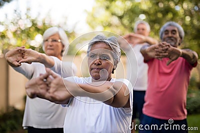 Senior friends stretching arms while exercising Stock Photo