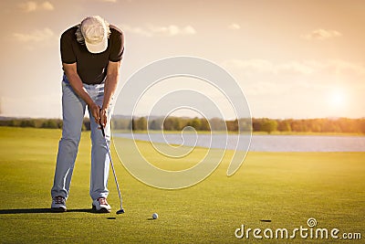 Senior golf player on green with copyspace. Stock Photo