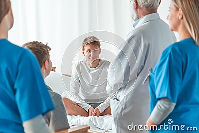 Grey doctor and female young intern working together at hospital Stock Photo