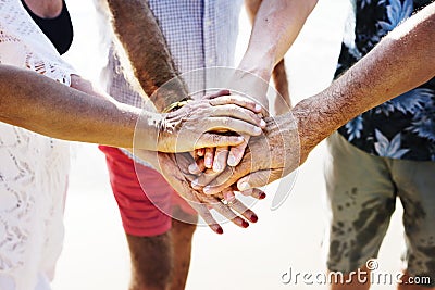 Senior hand stack together on beach Stock Photo