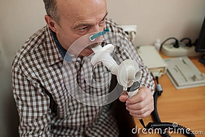 Senior hispanic man man testing breathing function by spirometry Stock Photo