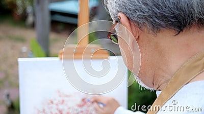 Senior holding color paint drawing on white paper Stock Photo