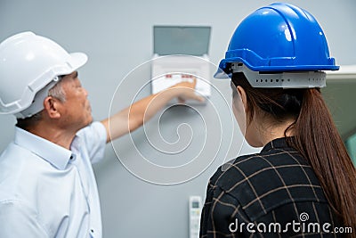 Senior home inspector checking home defects and teaching young engineers, before handing it over to client. Young engineers learn Stock Photo