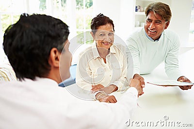 Senior Indian Couple Meeting With Financial Advisor At Home Stock Photo