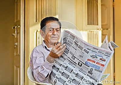 Senior Indian gent reading local newsprint Editorial Stock Photo