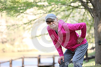 Senior Japanese man with lumbago pain during workout Stock Photo