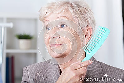 Senior lady combing hair Stock Photo