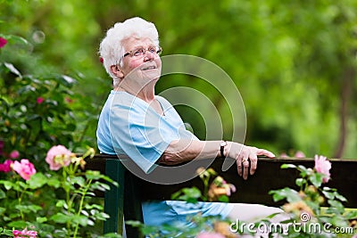 Senior lady in rose garden Stock Photo