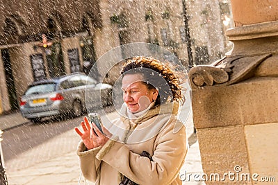 Senior lady trying to take photo in rainy England Stock Photo
