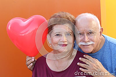 Senior Latino Couple holding a heart balloon Stock Photo