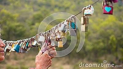 Senior look at colorful locks hang on cable with blurry nature background. love and safety life new normal concept Stock Photo
