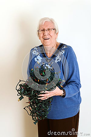 Senior mad at tangled christmas lights Stock Photo