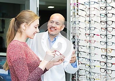 Optician offering glasses to woman Stock Photo