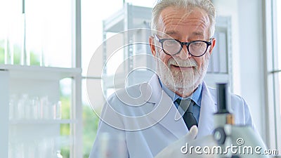 Senior male researcher think with face concentration about scientific research in a lab. With the foreground of equipment testing Stock Photo