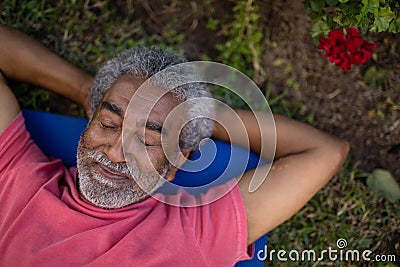 Senior male resting with closed eyes on exercise mat Stock Photo