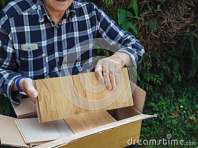 senior male unboxing unpacking parquet wooden floor samples Stock Photo