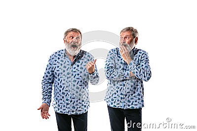 Senior man arguing with himself on white studio background. Stock Photo