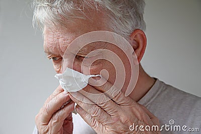 Senior man blows his nose with text space Stock Photo