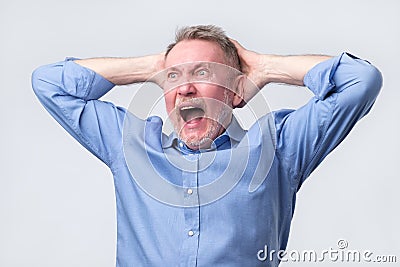 Senior man with angry grimace on his face,with mouth opened in shout Stock Photo