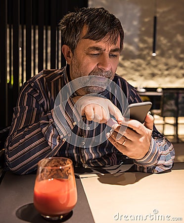 Senior man in casual clothes using mobile phone Stock Photo
