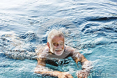 Senior man chilling in swimming pool Stock Photo