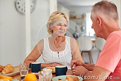 Senior Man Comforting Woman Suffering With Depression At Breakfast Table At Home Stock Photo